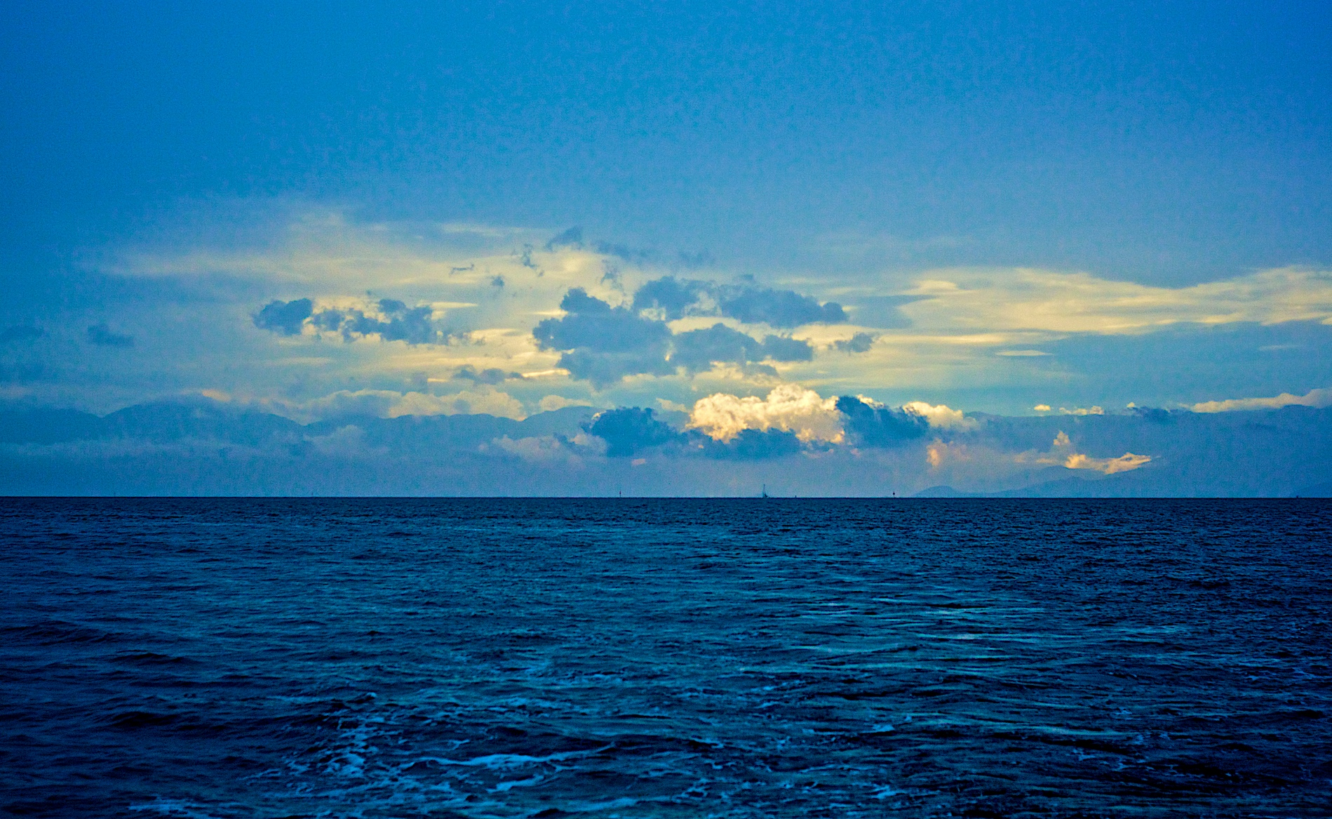 Open ocean horizon beneath a cloud-filled sky